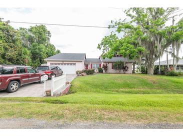 Charming single-story home with a well-maintained lawn and mature trees providing ample shade at 1354 S Shore Dr, St Cloud, FL 34771