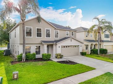 Charming two-story home with a well-manicured lawn and a spacious two-car garage at 1513 Blue Sky Way, Clermont, FL 34714