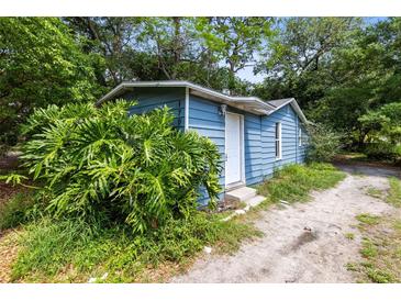 Charming single-story home featuring blue siding and lush greenery at 1701 E Bay St, Winter Garden, FL 34787
