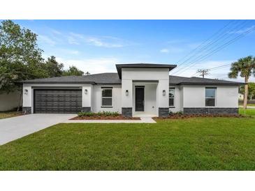 Modern home featuring a black garage door, neutral colors, and dark stone accents at 18743 Overton St, Orlando, FL 32833