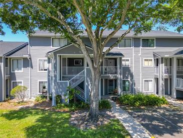 Inviting condo exterior with lush lawn and mature shade tree at 2216 Stonington Ave # 2216, Orlando, FL 32817