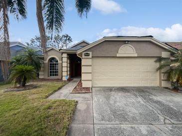 Charming single-story home featuring a two-car garage, neutral stucco, and lush tropical landscaping at 2226 Newt St, Orlando, FL 32837
