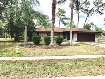Well-maintained single-story brick home with mature landscaping and a paved driveway at 3152 Clewiston St, Deltona, FL 32738