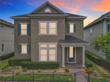 Charming two-story home featuring a manicured lawn, complemented by vibrant flowerbeds and a secure, decorative black metal fence at 473 Oviedo Blvd, Oviedo, FL 32765