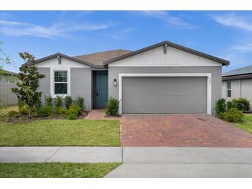 Charming single-Gathering home with a brick driveway, two-car garage, and well-maintained landscaping at 523 Tortugas St, Haines City, FL 33844