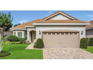 Charming home featuring a two-car garage, neutral paint, brick driveway, manicured lawn, and mature landscaping at 578 Newhall Ln, Debary, FL 32713