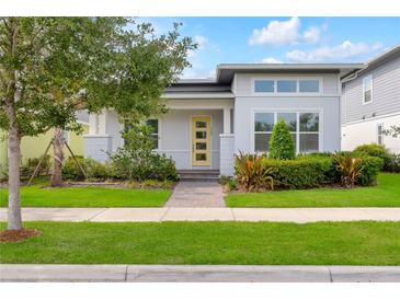 Charming single Gathering home showcasing a modern architectural style, professional landscaping, and a bright yellow front door at 7789 Nemours Pkwy, Orlando, FL 32827