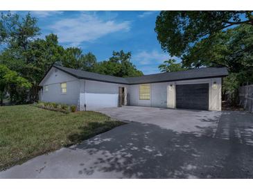Charming single-story home with a fresh white painted brick and a well-manicured lawn at 7813 Delphia St, Orlando, FL 32807