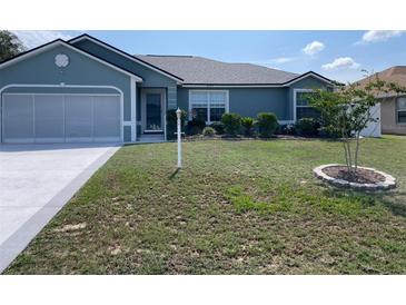 Charming single-story home boasts a well-manicured lawn, mature landscaping, and a two-car garage at 8187 Sw 60Th Ter, Ocala, FL 34476