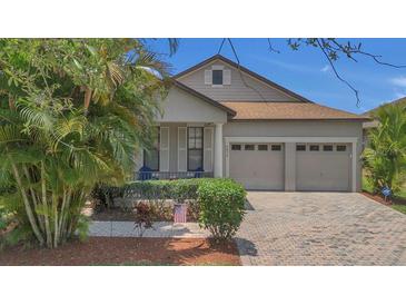 Charming home features a well-manicured lawn, neutral paint, shutters, and an attached two-car garage at 9836 Lake District Ln, Orlando, FL 32832