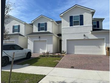 Inviting exterior view of modern two-story home with brick driveway, well maintained lawn, and attached garage at 1190 Seaside Mist Trl, Kissimmee, FL 34747