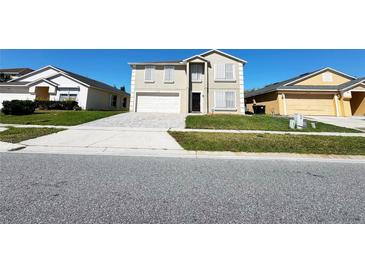 Charming two-story home with a well-manicured lawn and a paved driveway, reflecting curb appeal at 13046 Prairie Meadows Dr, Orlando, FL 32837