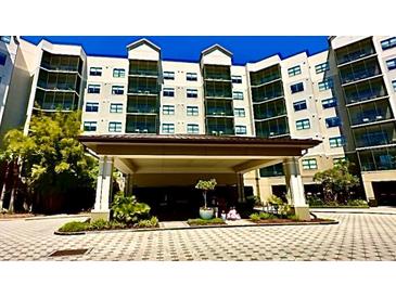 Beautiful multi-story condominium building with welcoming entrance and lush landscaping at 14501 Grove Resort Ave # 3636, Winter Garden, FL 34787