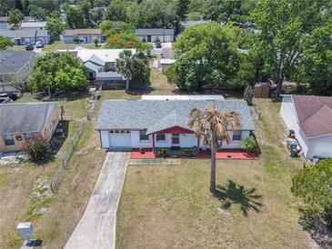 Charming single-story home featuring a well-maintained yard and a long driveway leading to an attached garage at 186 Tulpan Dr, Kissimmee, FL 34743