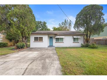 Charming single-story home with a well-maintained lawn, blue door, and mature trees at 2123 Weber St, Orlando, FL 32803