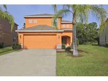 Two-story home with a two-car garage and landscaping in a well-maintained front yard at 2660 Santosh Cv, Kissimmee, FL 34746