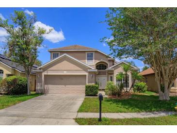 Two-story home with a front-facing two-car garage, manicured lawn and established trees at 2903 Joseph Cir, Oviedo, FL 32765