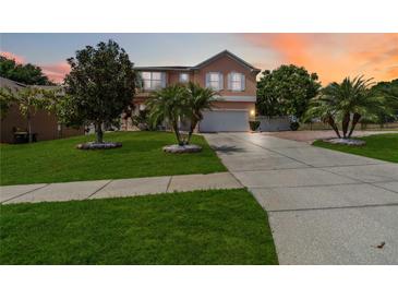 Charming two-story home with lush landscaping, palm trees, and a spacious driveway at 294 Hunt St, Clermont, FL 34711