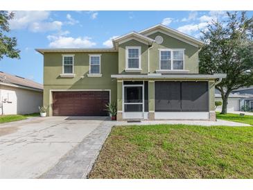 Two-story home with a well-maintained lawn, screened front porch, and a two car garage at 3842 Klondike Pl, Sanford, FL 32771