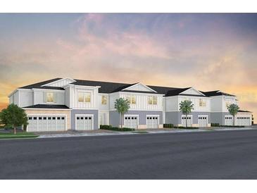Attractive three-story townhome featuring an attached garage and well-maintained landscaping at 393 Meadowland Pt, Oviedo, FL 32765