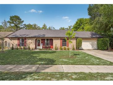 Charming brick home with a well-maintained front yard and red shutters offers classic curb appeal at 620 Fruitwood Ave, Winter Springs, FL 32708