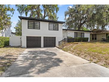 Two-story home with a 2-car garage, dark trim and a concrete driveway at 913 Moss Ln, Winter Park, FL 32789