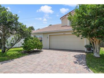 Charming single-Gathering home featuring a tile roof, brick driveway, and lush landscaping at 939 Glen Abbey Cir, Winter Springs, FL 32708