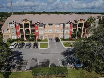Apartment complex with colorful exterior, parking, and beautiful landscaping at 2208 Antigua Pl # 932, Kissimmee, FL 34741