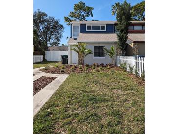 Charming two-story home featuring a well-manicured lawn, decorative landscaping and a white picket fence at 2714 Hunt Club Ln, Orlando, FL 32826