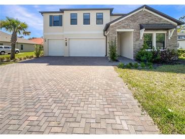 Beautiful two-story home featuring a brick driveway, stone accents, a two-car garage, and well-manicured landscaping at 4116 Se 9Th Ave, Ocala, FL 34480