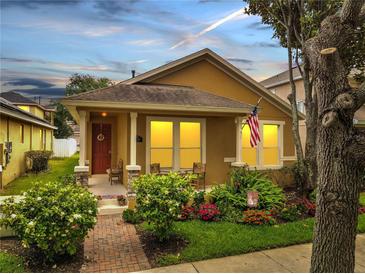 Charming single-Gathering home featuring a landscaped front yard and a cozy front porch with chairs at 6837 Pasturelands Pl, Winter Garden, FL 34787