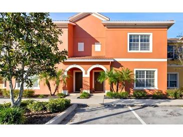 Charming two-story townhouse with a stucco facade, arched entrances, palm trees, and well-maintained landscaping at 8941 Bismarck Palm Rd, Kissimmee, FL 34747