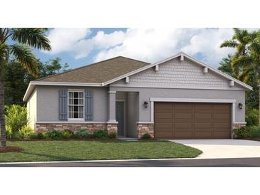 Charming single-story home featuring stone accents, grey exterior, and well-manicured lawn at 9169 Harris Hawk Dr, Leesburg, FL 34788