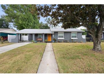 Charming one-story home with well-maintained lawn and a bright orange front door at 1094 Henry Balch Dr, Orlando, FL 32810
