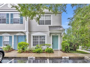 Inviting townhouse featuring a charming, light teal-colored front door and lush landscaping at 1150 Vineland Pl, Lake Mary, FL 32746