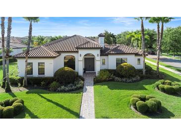 Inviting single-story home with manicured landscaping and a paver walkway leading to the front door at 11706 Waterstone Loop Dr, Windermere, FL 34786