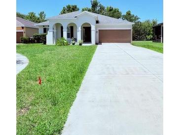 Charming single-story home with well-maintained lawn and long driveway at 1726 Brassie Ct, Kissimmee, FL 34746