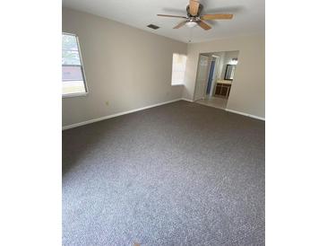 This bedroom features neutral walls, carpeted floors, and a ceiling fan at 1880 N Crystal Lake Dr # 3, Lakeland, FL 33801