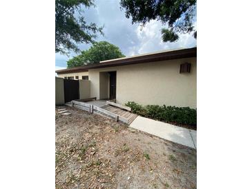 Beige single story home featuring a walkway leading to front door and landscaped details at 1880 N Crystal Lake Dr # 3, Lakeland, FL 33801