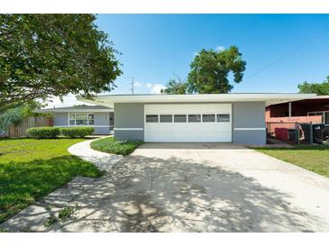 Charming home featuring a large garage, well-manicured lawn, and inviting curb appeal on a sunny day at 2736 Shannon Rd, Orlando, FL 32806