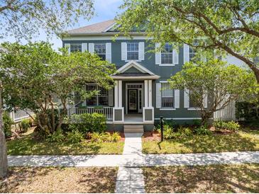 Charming two-story home featuring a beautifully landscaped front yard with mature trees and inviting walkway at 3813 Goldenglow Dr, Orlando, FL 32828