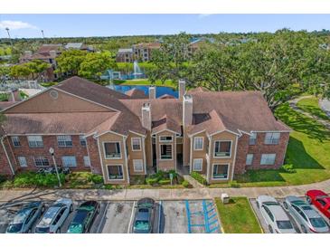 Beautiful exterior view of the complex with a fountain and well-manicured landscaping at 4400 Thornbriar Ln # 104, Orlando, FL 32822
