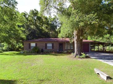 Charming brick home with mature trees and well-manicured lawn at 4519 Se 140Th Pl, Summerfield, FL 34491