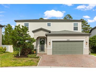 Charming two-story home features a brick driveway, neutral paint, and manicured landscaping at 5458 Carrara Ct, St Cloud, FL 34771