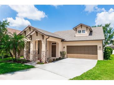 Charming single-Gathering home featuring a two-car garage, stone accents, and a well-manicured lawn at 6728 Duncaster St, Windermere, FL 34786