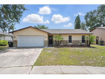 Charming single-story home features a well-maintained lawn, two car garage, and decorative stone accents at 2527 Christine Dr, Kissimmee, FL 34744