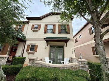 Charming townhome featuring shutters, stone accents, and a cozy front porch at 10631 Village Lake Rd, Windermere, FL 34786