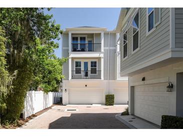 Charming three-story townhome showcasing a two-car garage and dual balconies at 117 E Concord St # 7, Orlando, FL 32801