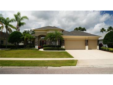 Charming single-story home with a three car garage, manicured lawn, and lush landscaping at 13016 Islamorada Dr, Orlando, FL 32837