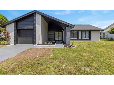 Charming single-story home featuring dark accents, a well-manicured lawn, and a welcoming entrance at 17 S Flag Ct, Kissimmee, FL 34759